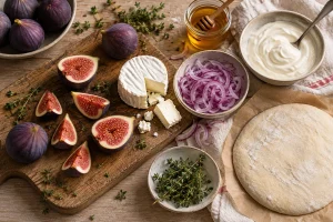 Frische Feigen, Ziegenkäse, rote Zwiebel und Flammkuchenteig auf dem Tisch