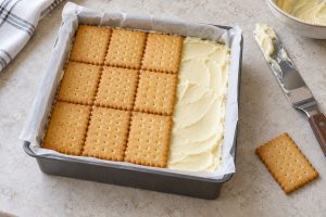 Quadratische Form mit Vanillecreme und einer teilweise aufgelegten oberen Butterkeksschicht